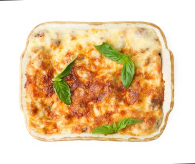 Pişirme kabında nefis pişmiş lazanya ve beyaza izole edilmiş fesleğen.