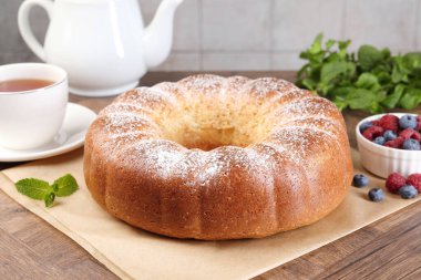 Taze pişmiş sünger keki, nane, böğürtlen ve çay ahşap masada, yakın plan.