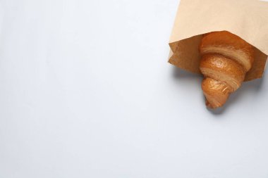 Beyaz zemin üzerinde taze kruvasan olan kağıt torba. Metin için boşluk