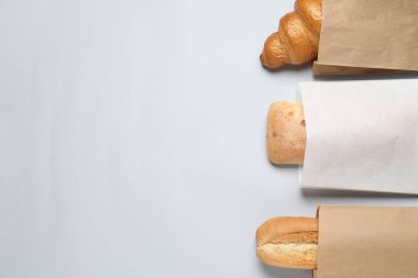 Beyaz arka planda taze hamur işleriyle dolu kağıt torbalar. Metin için boşluk