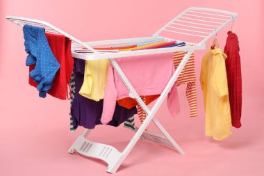 Açık pembe arka planda temiz çamaşırlı kuru askı.