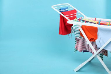 Açık mavi arka planda temiz çamaşırları olan kuru askı. Metin için boşluk