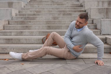 Düştükten sonra merdivenlerde yaralı bir adam var. Tehlikeli bir kaza.