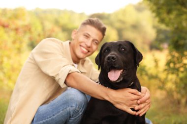 Açık havada gülümseyen sevimli bir köpek, seçici bir odak noktası.