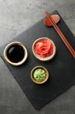 Sıcak wasabi ezmesi, soya sosu, zencefil ve çubuklar gri desenli masa, üst manzara