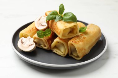 Lezzetli rulo krep, mantarlı ve fesleğenli beyaz mermer masa, yakın plan.