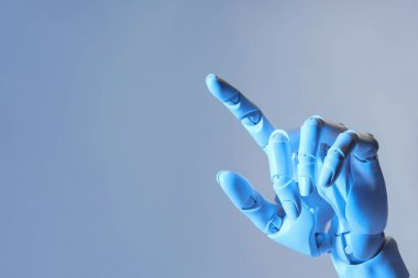 Yapay zeka. Robot el açık mavi arkaplanda bir şeye işaret ediyor, metin için boşluk
