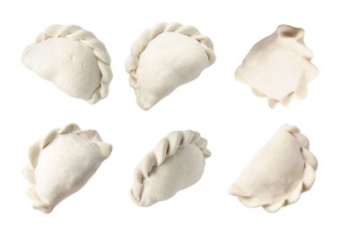 Beyaz arkaplanda çok sayıda çiğ hamur köftesi (varenyky)