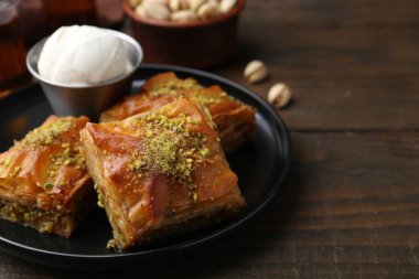 Ahşap masada ezilmiş fındıklı ve dondurmalı enfes baklava, yakın plan. Metin için boşluk