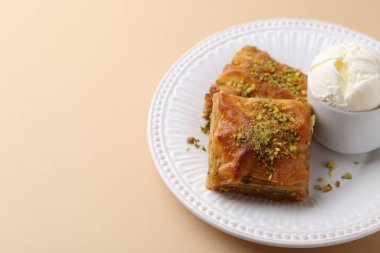 Bej masada ezilmiş fındıklı ve dondurmalı enfes baklava, yakın plan. Metin için boşluk