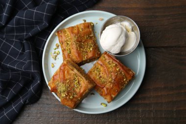 Ahşap masada ezilmiş fındıklı ve dondurmalı enfes baklavalar.
