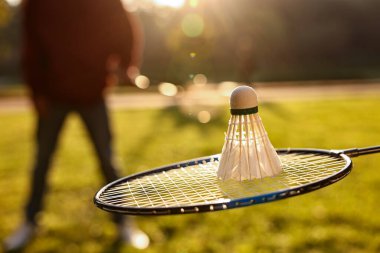 Güneşli bir günde parkta Badminton raketi ve mekik horozu, seçici odaklanma