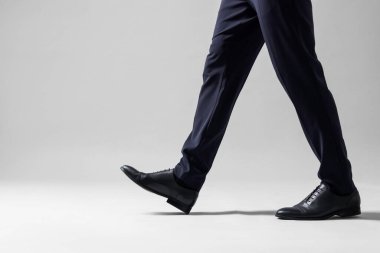 Businessman walking on light grey background, closeup clipart