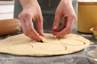 İçerideki gri masada pirozhki yapan kadın, yakın plan.