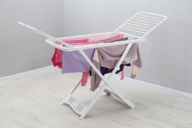 Gri duvarın yanında temiz çamaşırları olan kuru askı.