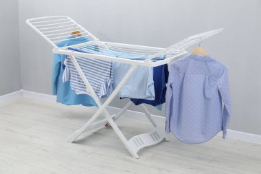 Gri duvarın yanında temiz çamaşırları olan kuru askı.