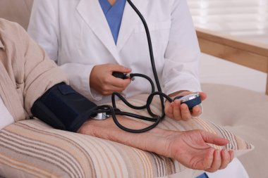 Doktor içeride hastanın kan basıncını ölçüyor, yakın plan.