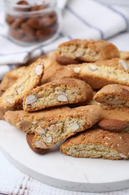 Lezzetli bademli bisküviler (Cantuccini) ve beyaz ahşap masada fındıklar, yakın plan.