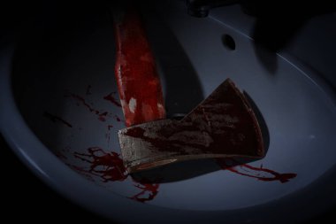 Axe with blood in sink, above view clipart