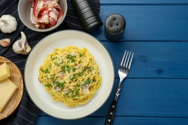 Lezzetli makarna Carbonara servis edilir mavi ahşap masa, düz yatıyordu