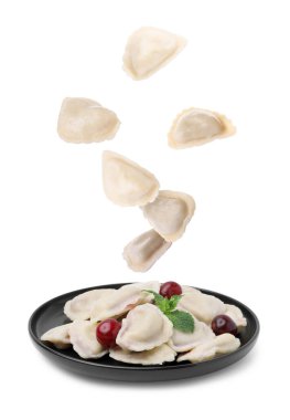 Hamur köfteleri (varenyky) ve kirazlar beyaz arka plana dökülüyor