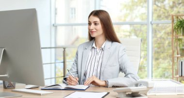 Banker ofisteki masada notlar alıyor.