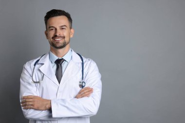Gri arka planda steteskobu olan gülümseyen doktor, metin için boşluk