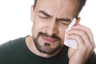 Beyaz arka planda ağlayan kağıt mendilli üzgün adam.