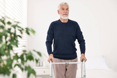 Hastane koğuşunda yürüyen yaşlı adam.