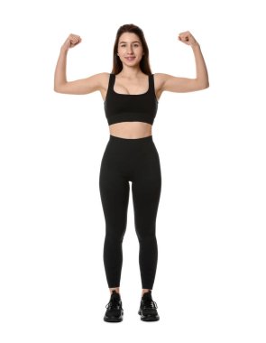 Spor kıyafetli bir kadın beyaz arka planda pazılarını gösteriyor.