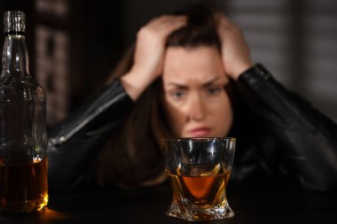 Alkol bağımlılığı. İçerideki kadın, viski ve şişeye odaklan.