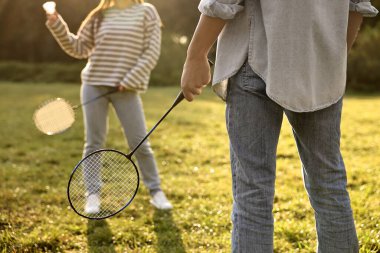 Güneşli bir günde parkta badminton oynayan kadın ve erkek, yakın plan.