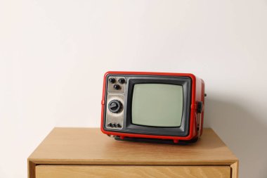 Beyaz duvara karşı komodinin üzerindeki Retro TV