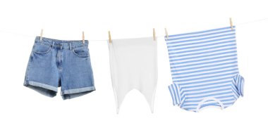 Different clothes drying on laundry line against white background