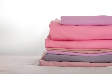 Yatağın üzerine katlanmış temiz çarşaf yığını. Metin için boşluk