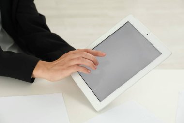 Beyaz masada tablet kullanan bir iş kadını, yakın plan. Modern teknoloji