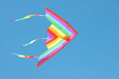 Mavi gökyüzünde uçan renkli bir uçurtma