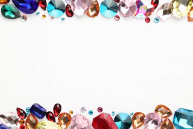 Beyaz arka planda, düz zeminde farklı parlak değerli taşların çerçevesi. Metin için boşluk