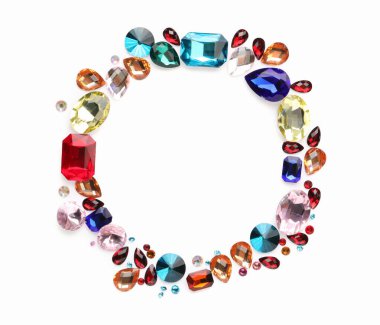 Beyaz arka planda, düz zeminde farklı parlak değerli taşların çerçevesi. Metin için boşluk