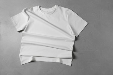 Gri desenli arka planda bir tişört, üst görünümde.