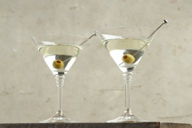 Ahşap masada zeytinli martini kokteyli.