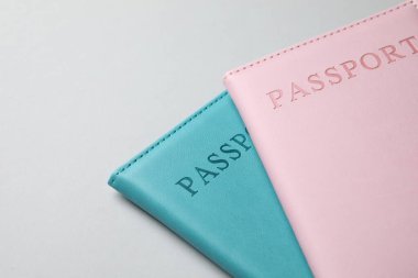 Işıklı arka planda renkli pasaportlar, yakın plan. Metin için boşluk