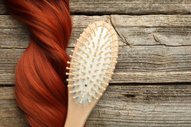 Tahta masanın üstünde saç fırçası ve bukle, üst manzara. Metin için boşluk