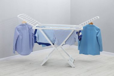 Gri duvarın yanında temiz çamaşırları olan kuru askı.