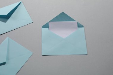 Gri arkaplanlı kağıt zarflar, düz yatış. Tasarım için model