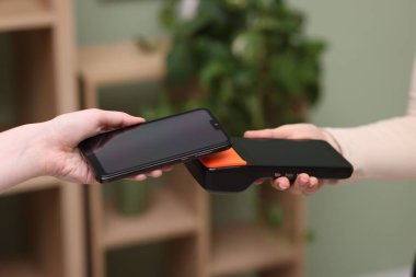 Bulanık arka planda akıllı telefondan ödeme yapan kadın, yakın plan