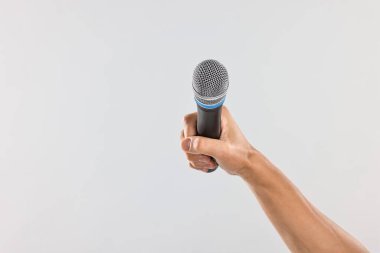 Açık gri arka planda mikrofonu olan adam, yakın plan. Metin için boşluk