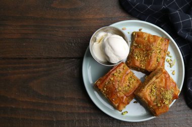 Ahşap masada ezilmiş fındıklı ve dondurmalı enfes bir baklava. Metin için boşluk