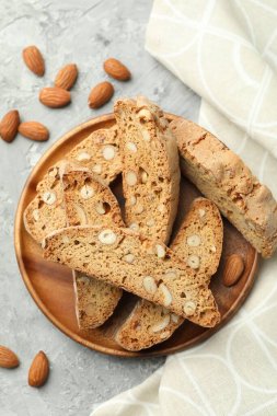 Geleneksel İtalyan badem bisküvileri (Cantucci) ve gri desenli masa üzerinde fındıklar, düz konum