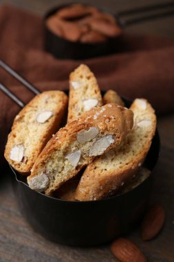 Lezzetli bademli bisküviler (Cantuccini) kepçe ve fındıklar ahşap masada, yakın plan